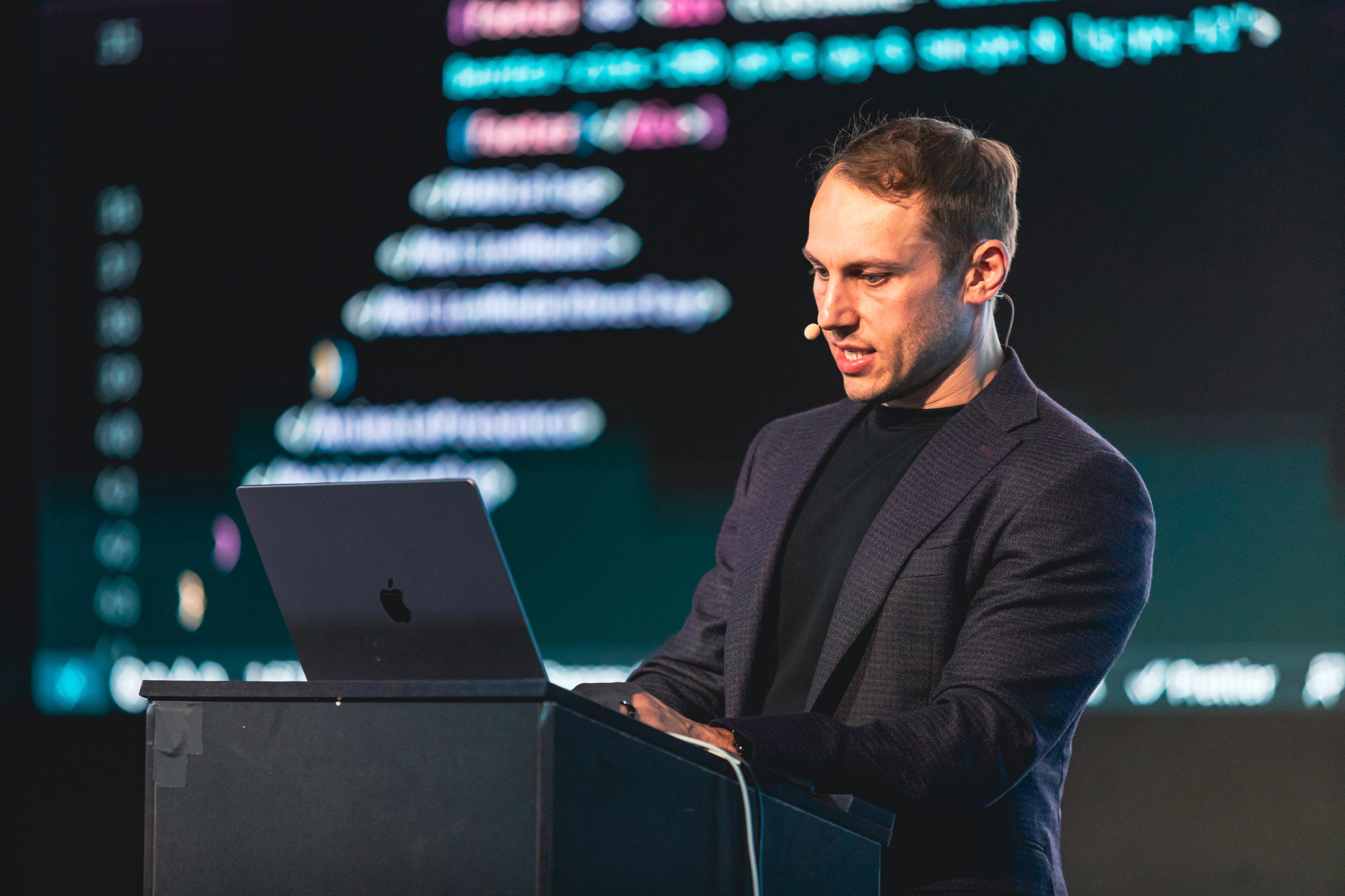 Adam Wathan on stage live-coding a demo with Tailwind CSS and Framer Motion